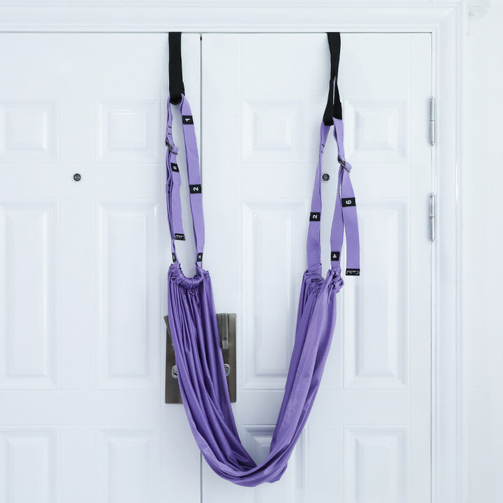 Yoga stretch strap hanging from a door